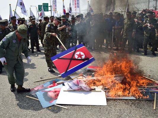 South Korean veterans burn placards of the North Korean flag and its leader Kim Jong-Un during a protest in Paju on Aug. 13 2015 denouncing a recent land mine attack at a military checkpoint near the DMZ dividing the two Koreas